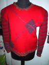 Vue de devant: rouge brique, deux losanges, broderie au point de maille.